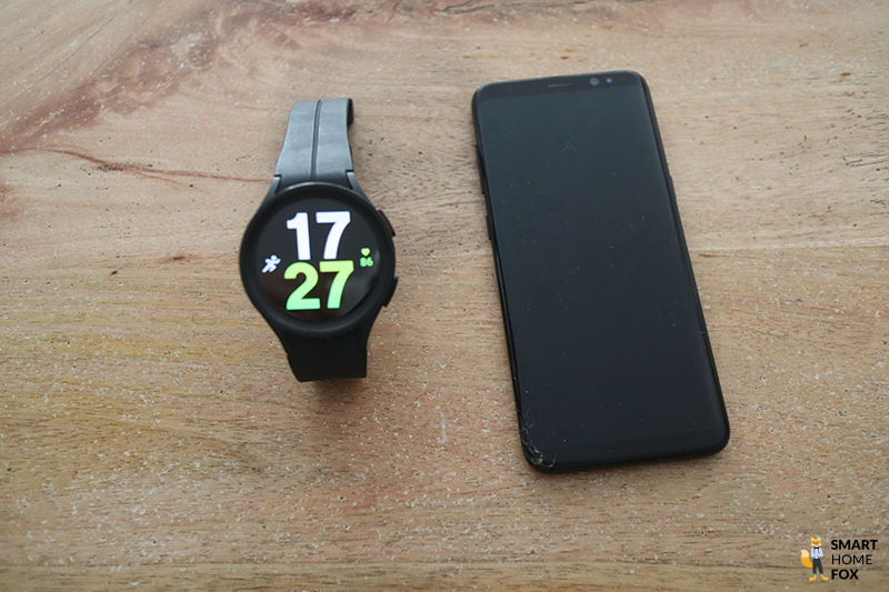 Man sieht die Galaxy Watch 5 neben einem Samsung Handy.